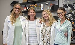 Katie Hurst, Jessica Thaxton, Kiley Lawrency and Ashton Basar stand together in the lab